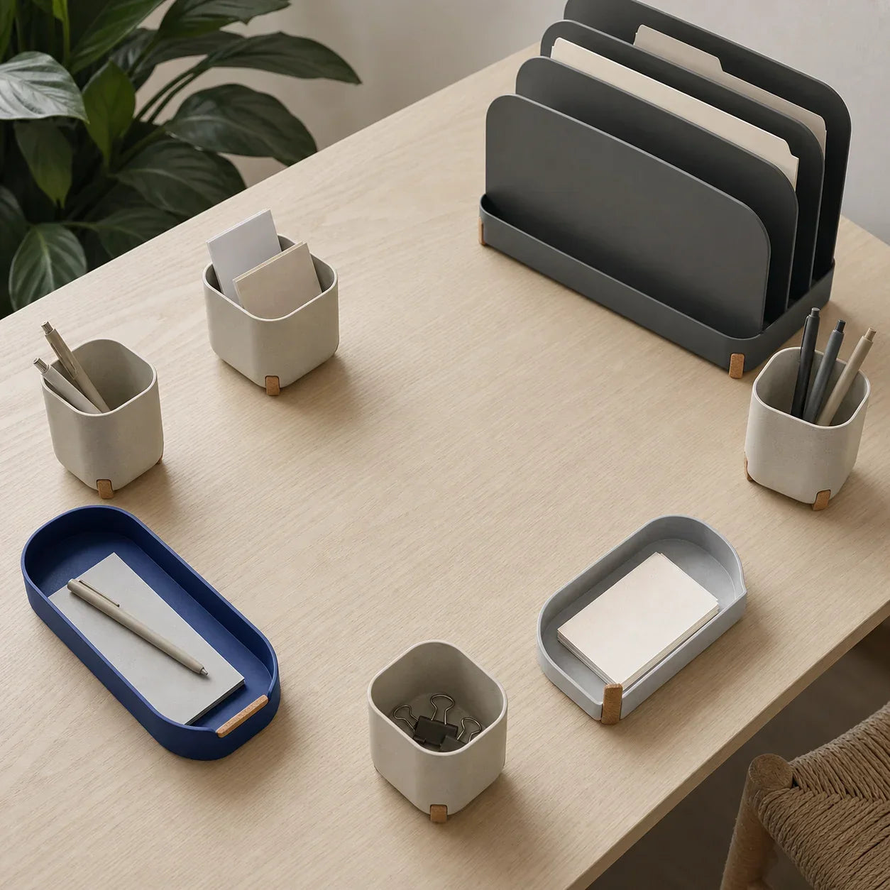Coordinated trays, small bins, and folders arranged along the perimeter of a work desk