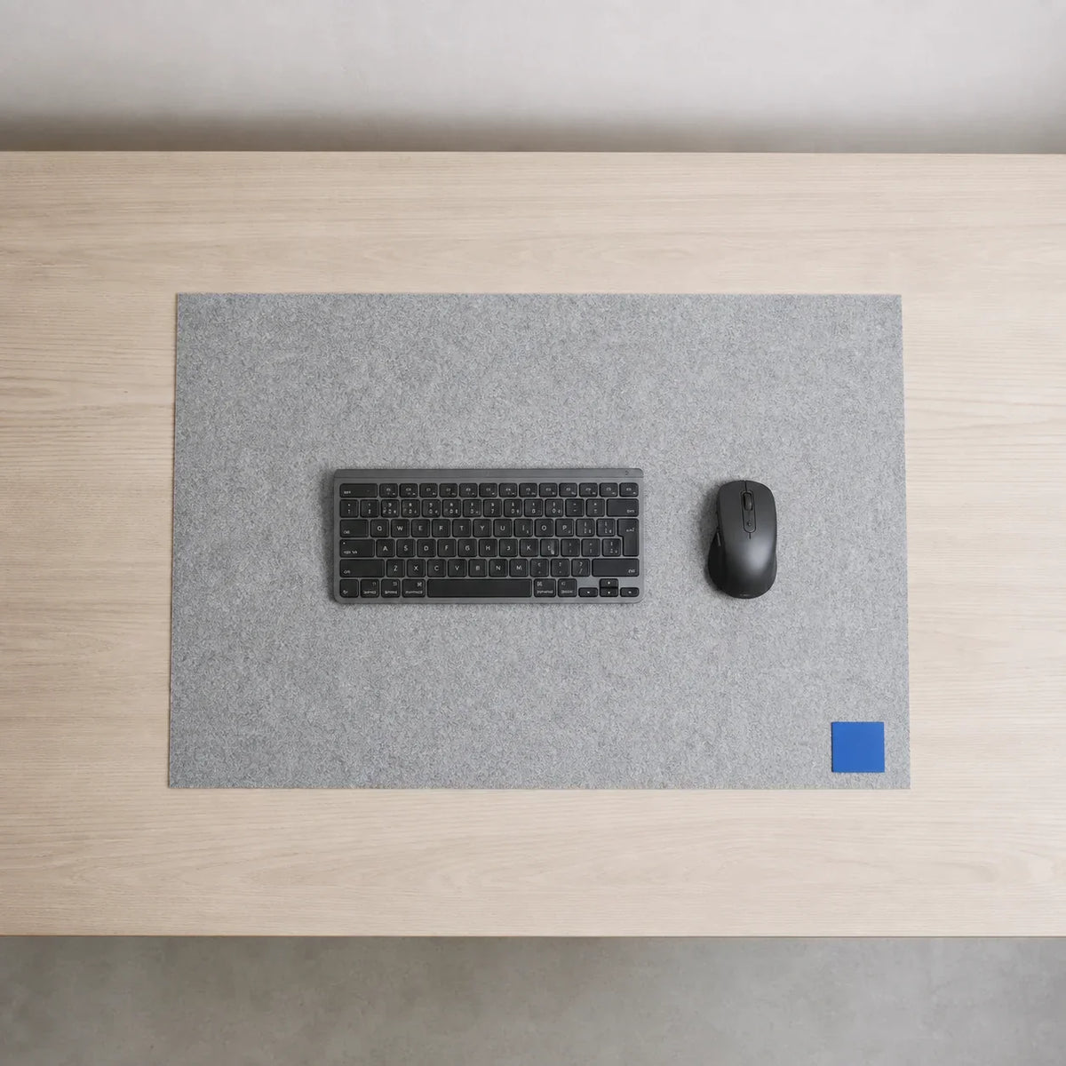 Top-down desk showing one clearly defined felt work surface with open space around its edges