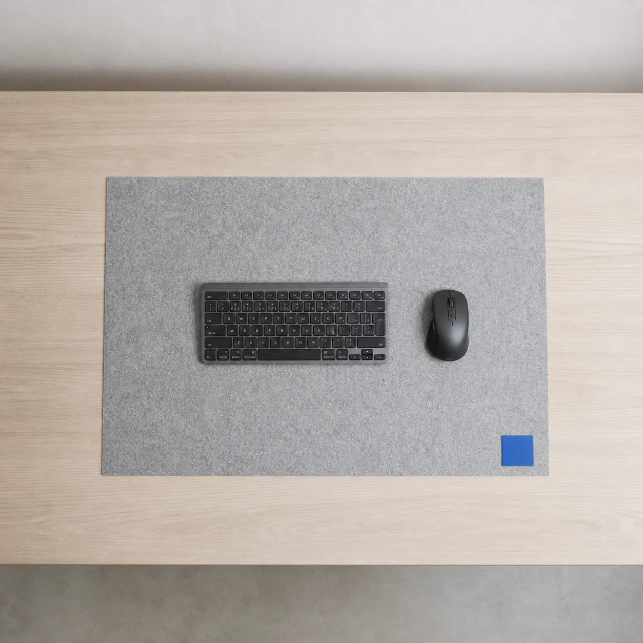 Top-down desk showing one clearly defined felt work surface with open space around its edges
